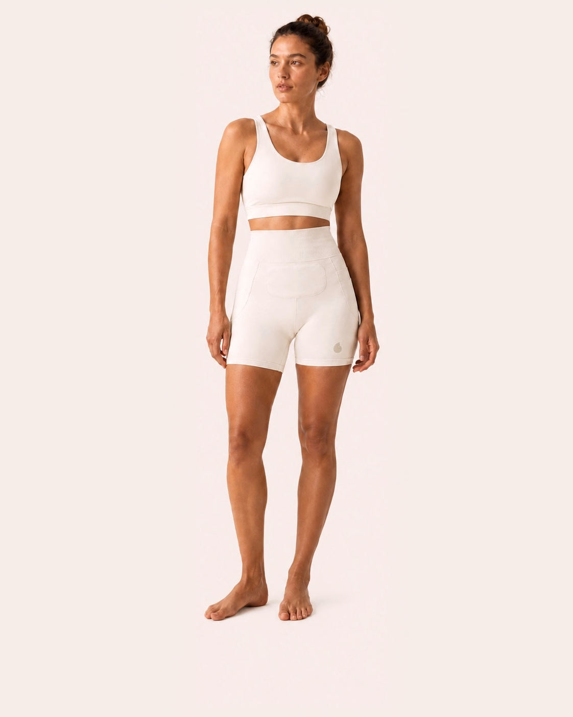 Une femme porte le short Simone en coloris Blanc sur un fond studio ivoire uniforme.