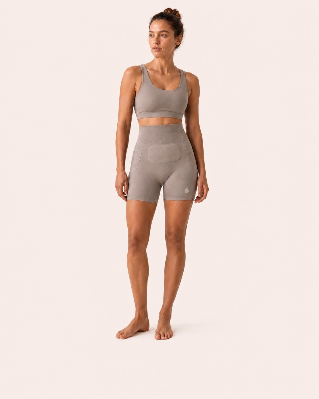 Une femme porte le short Simone en coloris Gris sur un fond studio ivoire uniforme.